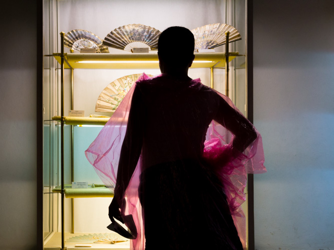 Plastique rose | Reales Alcázares. Visiteuse devant la vitrine des éventails royaux un jour de pluie. | © Gilles Vanderstraeten